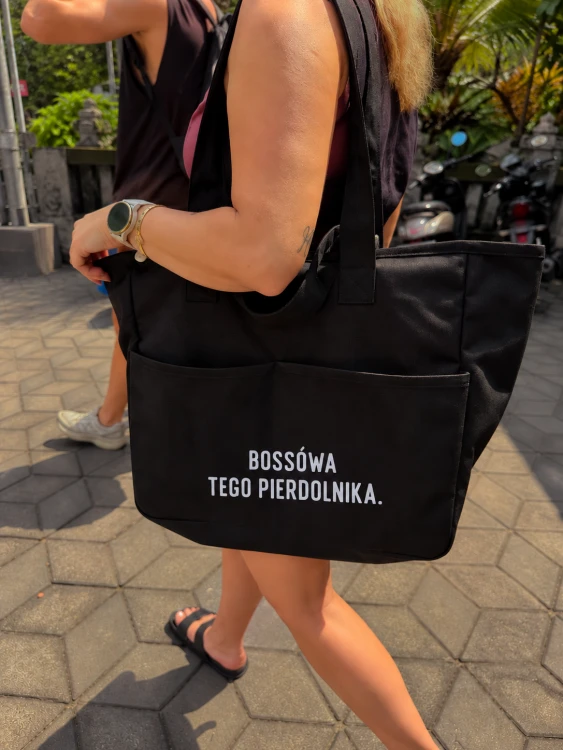 Czarna torba z odważnym hasłem nad ulicą.png
